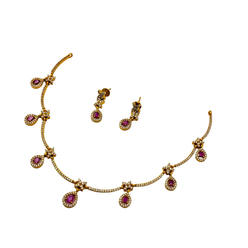 Gold necklace with pink gemstones and matching earrings on a white background
