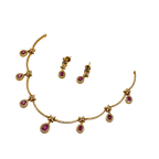 Gold necklace with pink gemstones and matching earrings on a white background