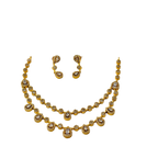 Gold necklace and earrings set on a white background
