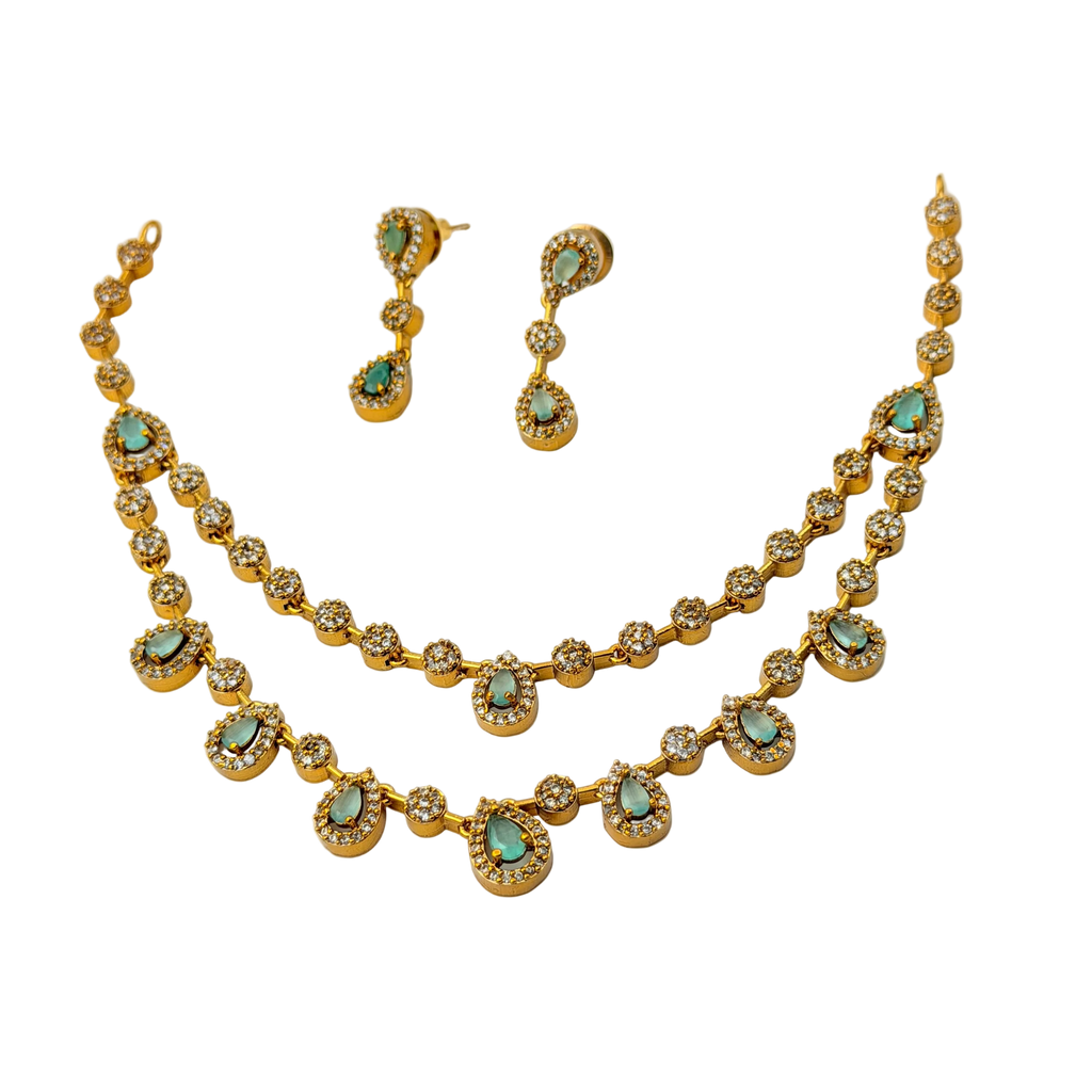 Gold necklace and earrings with turquoise stones on a white background