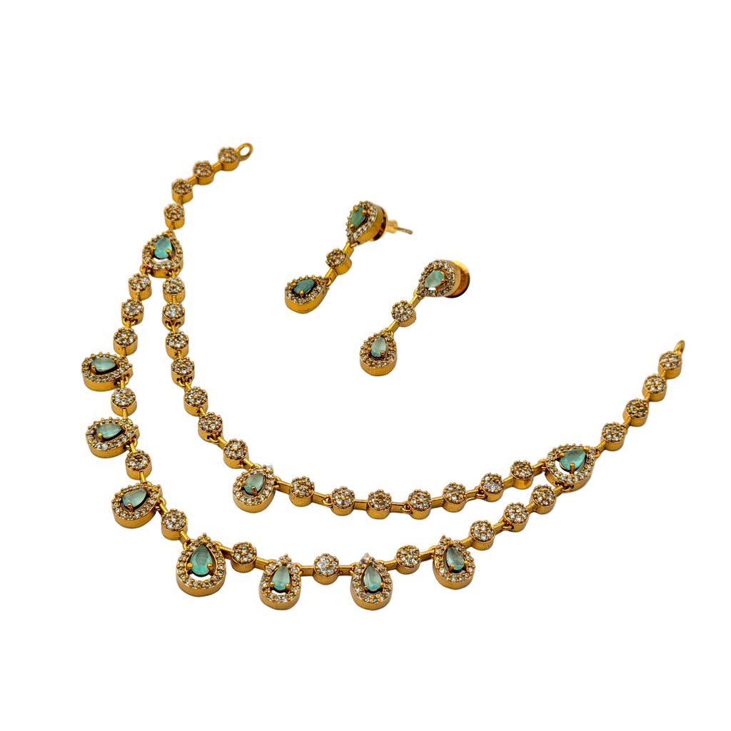 Gold necklace and earrings with turquoise stones on a white background