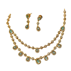 Gold necklace with green gemstones and matching earrings on a white background