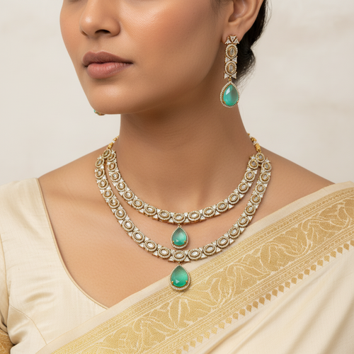 Woman wearing a gold necklace with green gemstones and matching earrings.