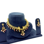 Gold necklace and earrings set on a blue velvet stand