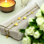 Gold-toned double-chain bracelet with flower charms and beads, worn on wrist poolside