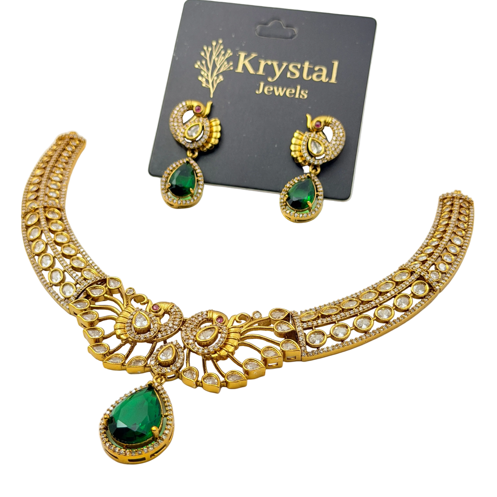 Gold necklace with green gemstones and matching earrings on a Krystal Jewels card.