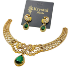 Gold necklace with green gemstones and matching earrings on a Krystal Jewels card.