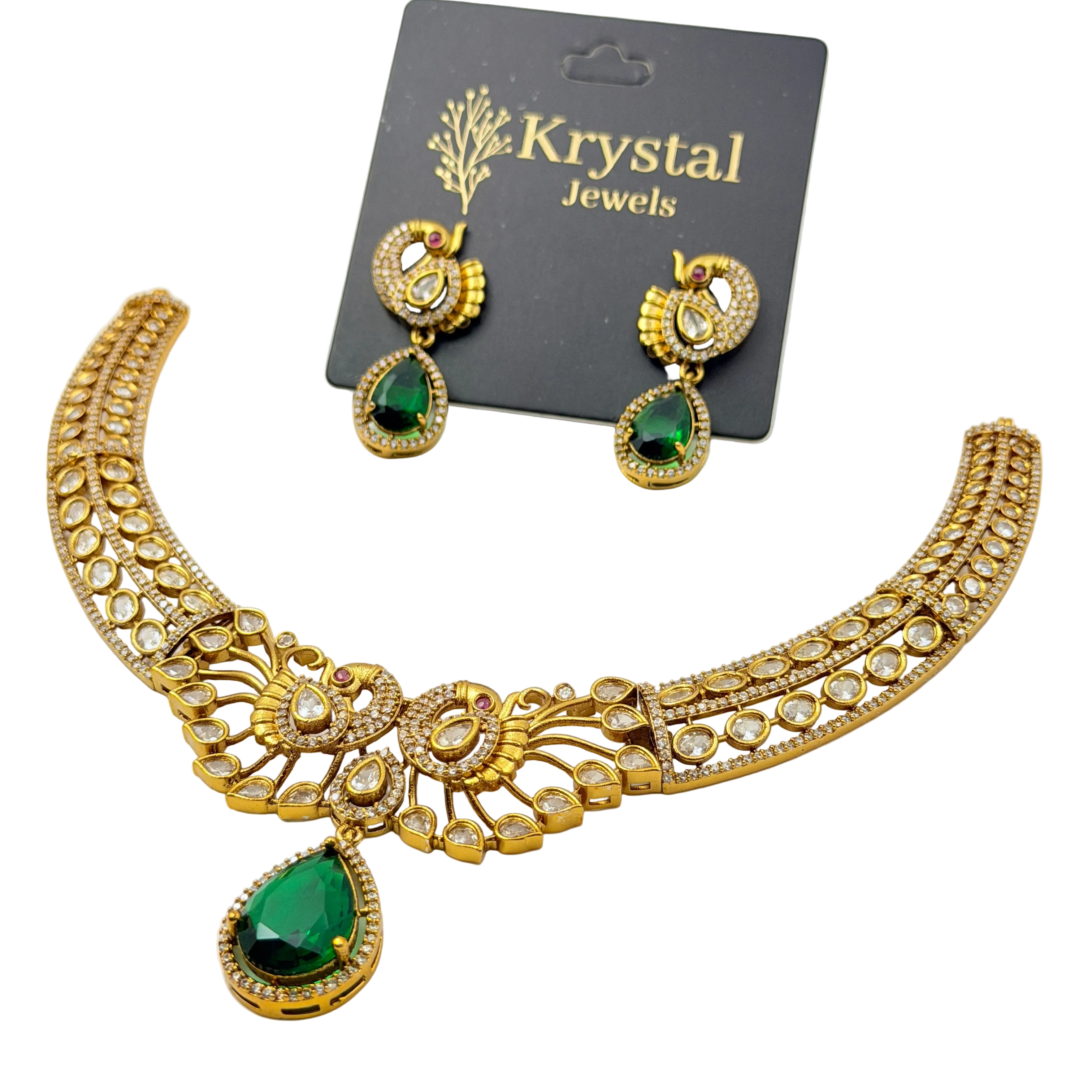 Gold necklace with green gemstones and matching earrings on a Krystal Jewels card.