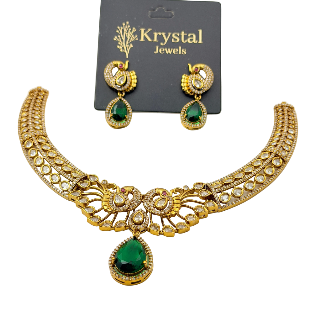 Gold necklace with green gemstones and matching earrings on a Krystal Jewels card.
