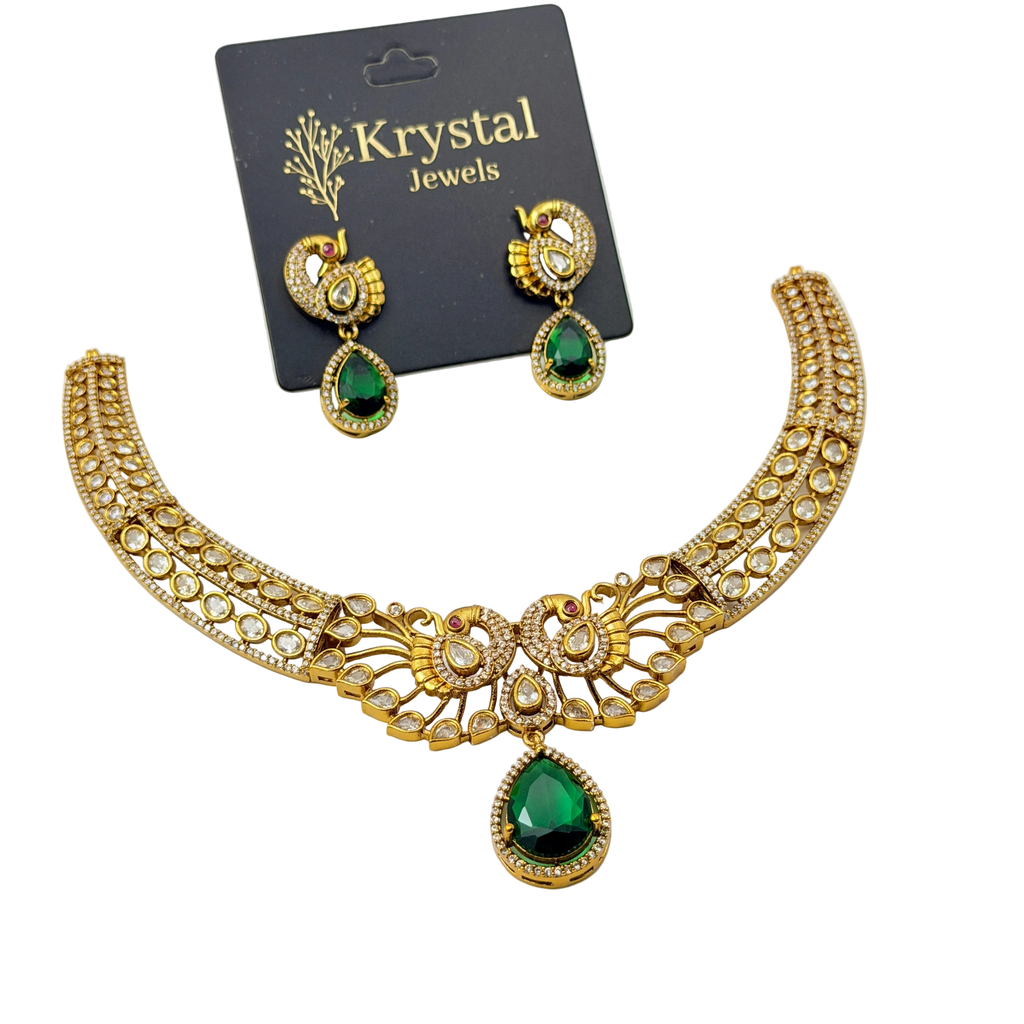 Gold necklace with green gemstones and matching earrings on a Krystal Jewels card.
