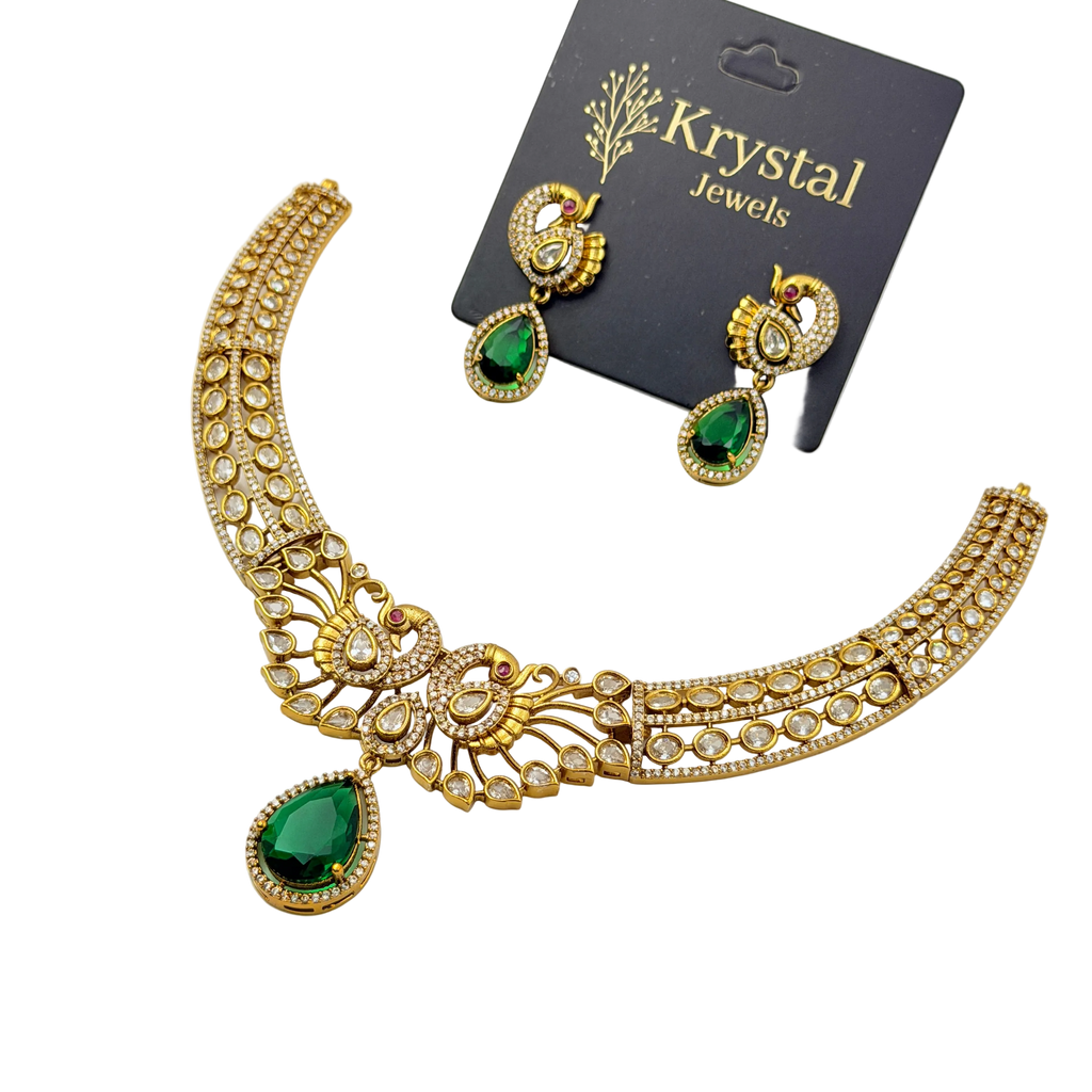 Gold necklace with green teardrop pendants and matching earrings on a Krystal Jewels card.