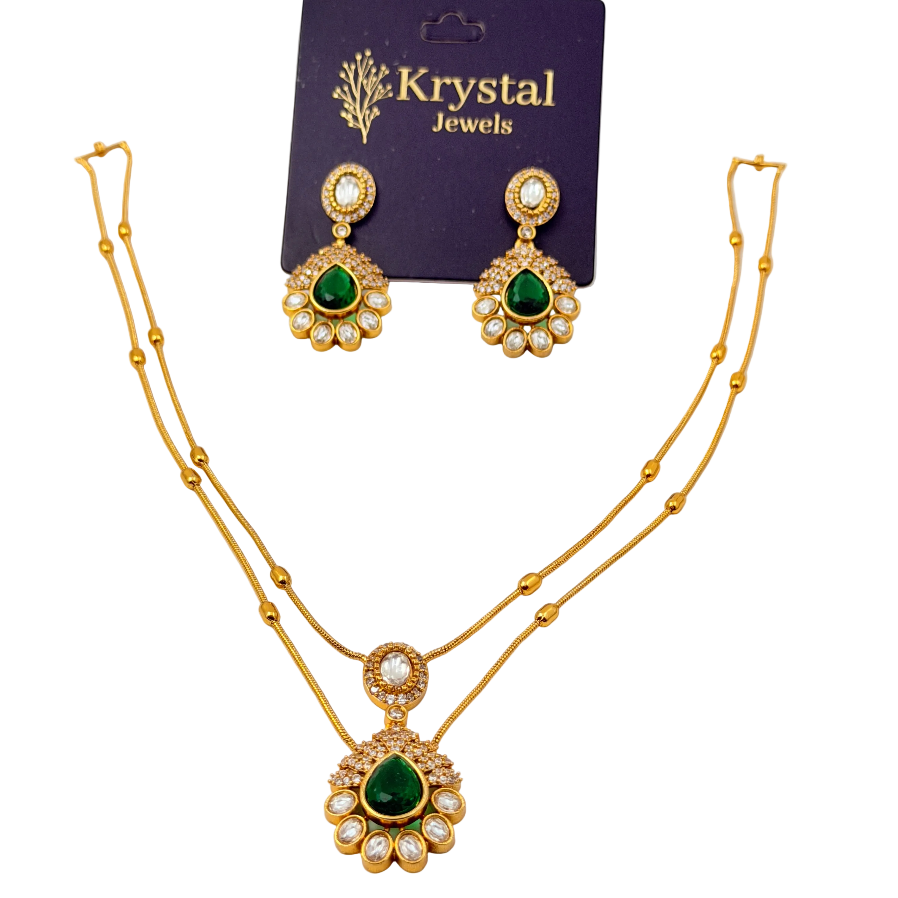 Gold necklace and earrings with green gemstones on a Krystal Jewels card.