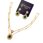 Gold necklace with green gemstones and matching earrings on a Krystal Jewels card.