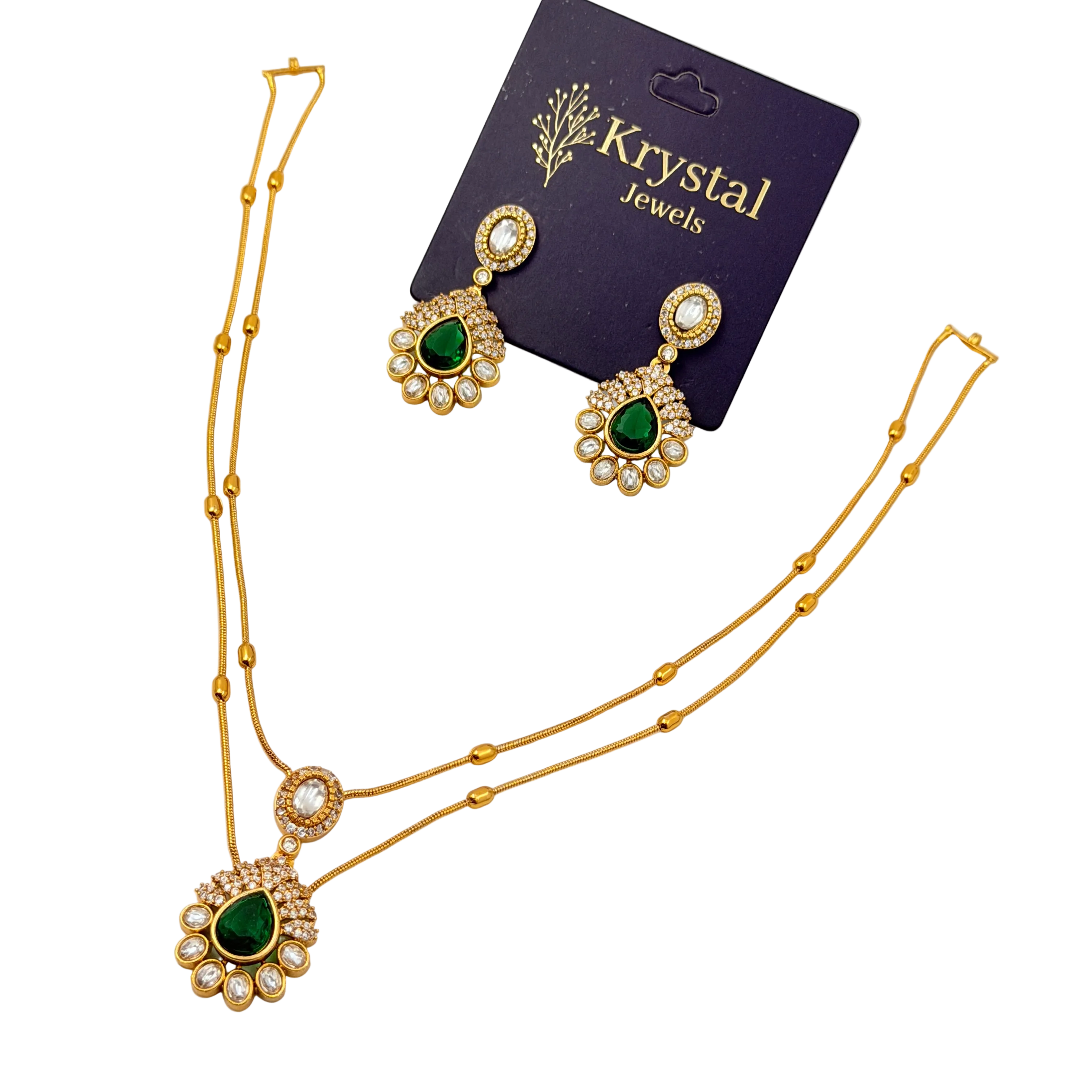 Gold necklace with green gemstones and matching earrings on a Krystal Jewels card.