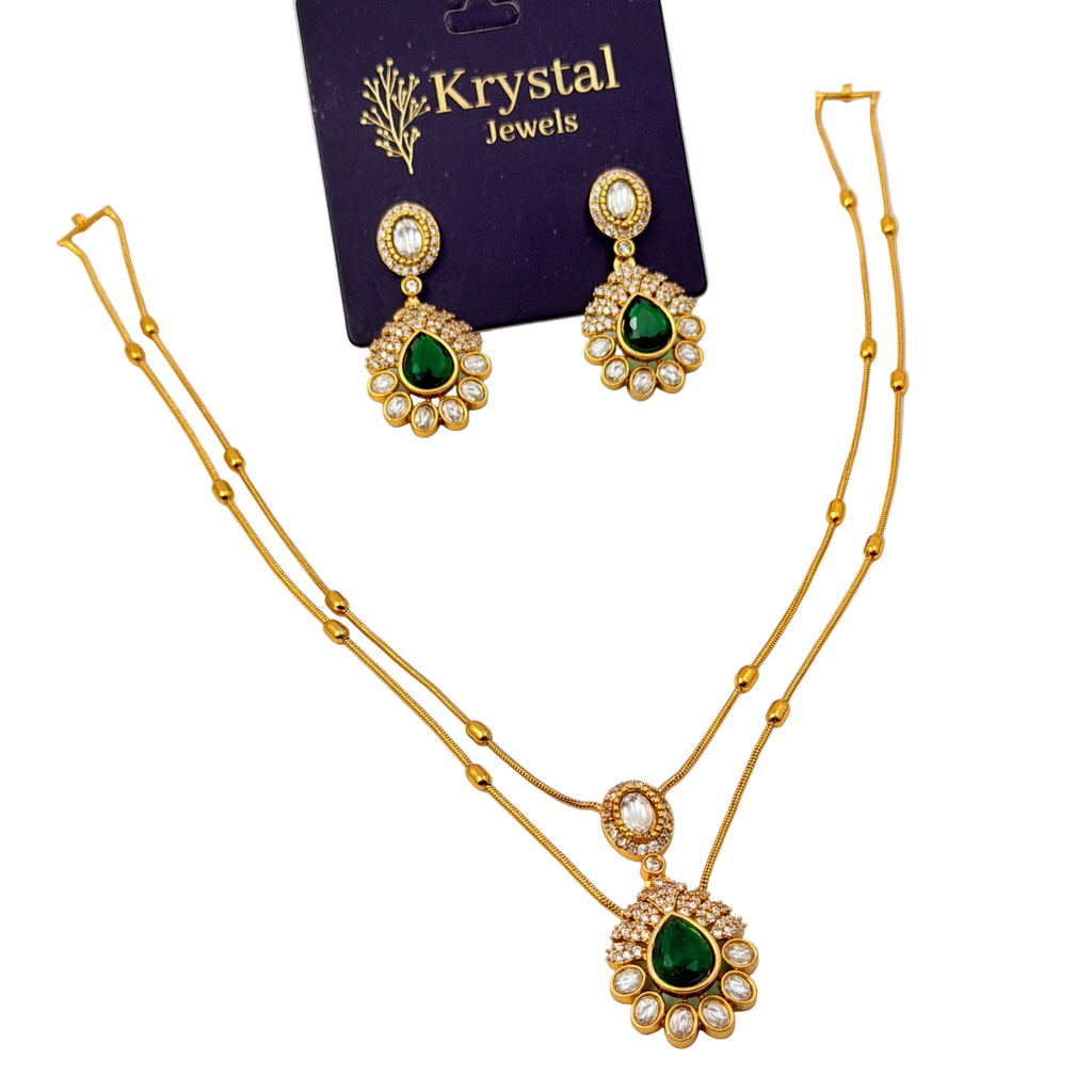 Gold necklace with green gemstones and matching earrings on a Krystal Jewels card.