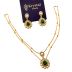Gold necklace with green gemstones and matching earrings on a Krystal Jewels card.