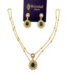 Gold necklace with green gemstones and matching earrings on a Krystal Jewels card.