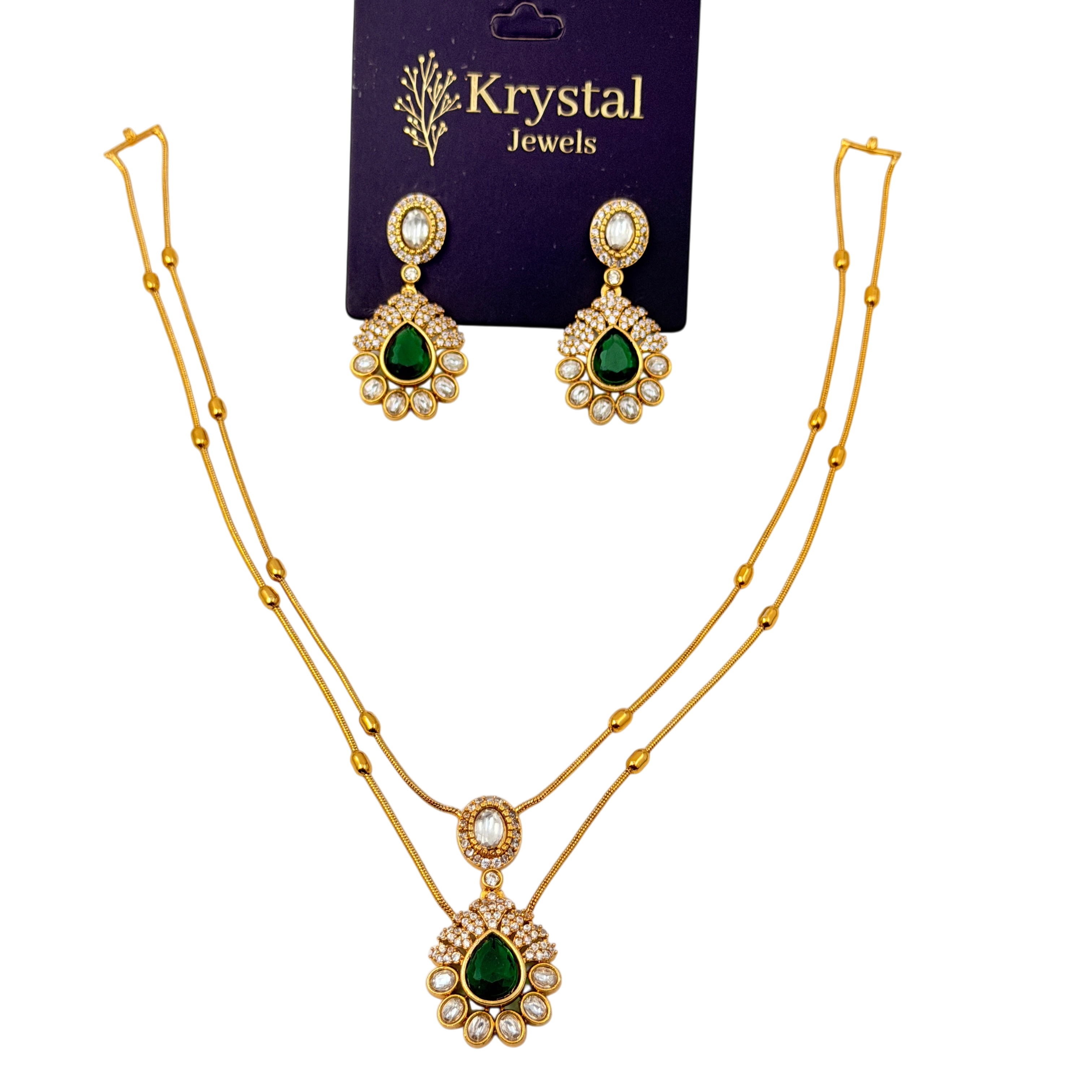 Gold necklace with green gemstones and matching earrings on a Krystal Jewels card.
