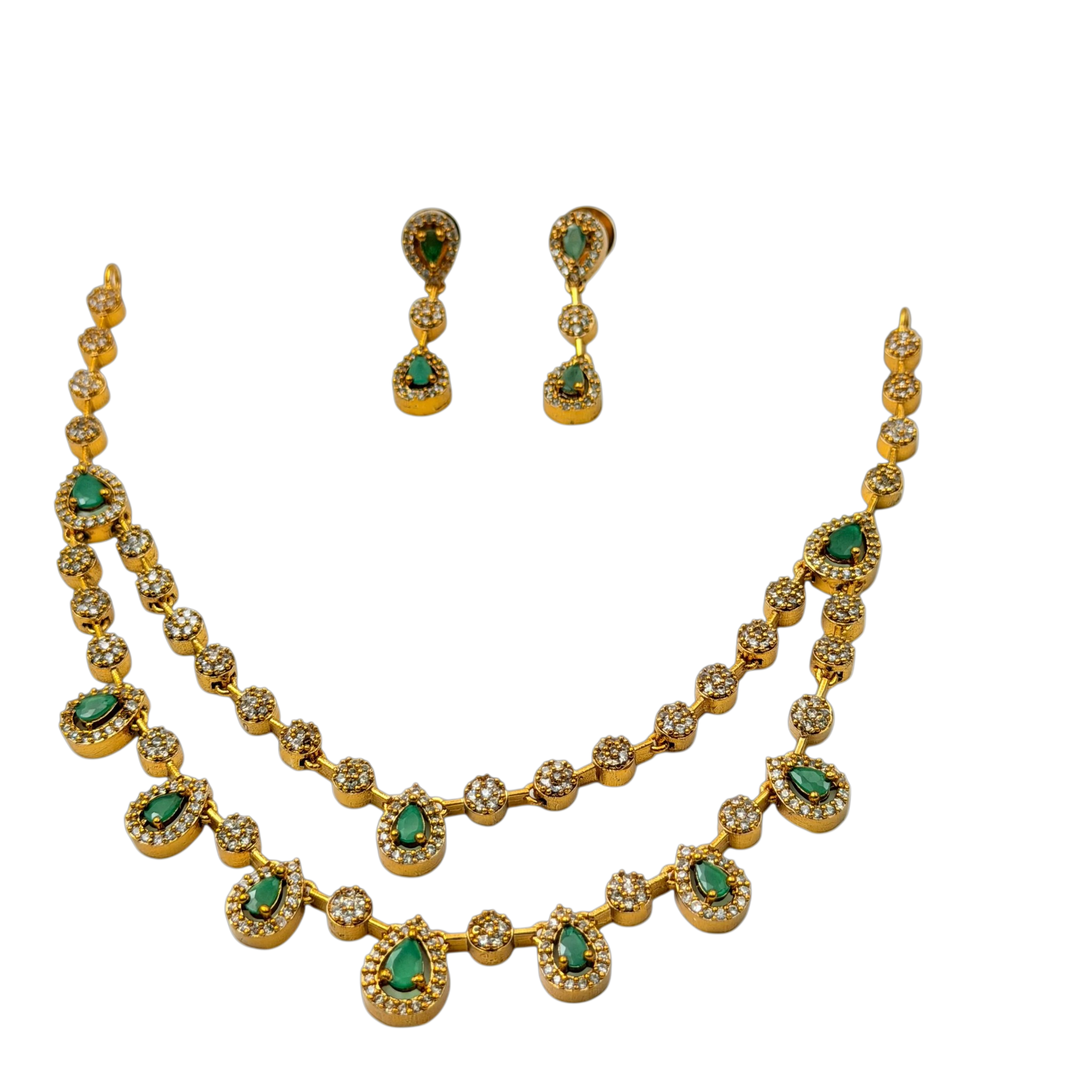 Gold necklace and earrings with green gemstones on a white background