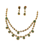 Gold necklace with green gemstones and matching earrings on a white background