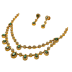 Gold necklace and earrings with green gemstones on a white background