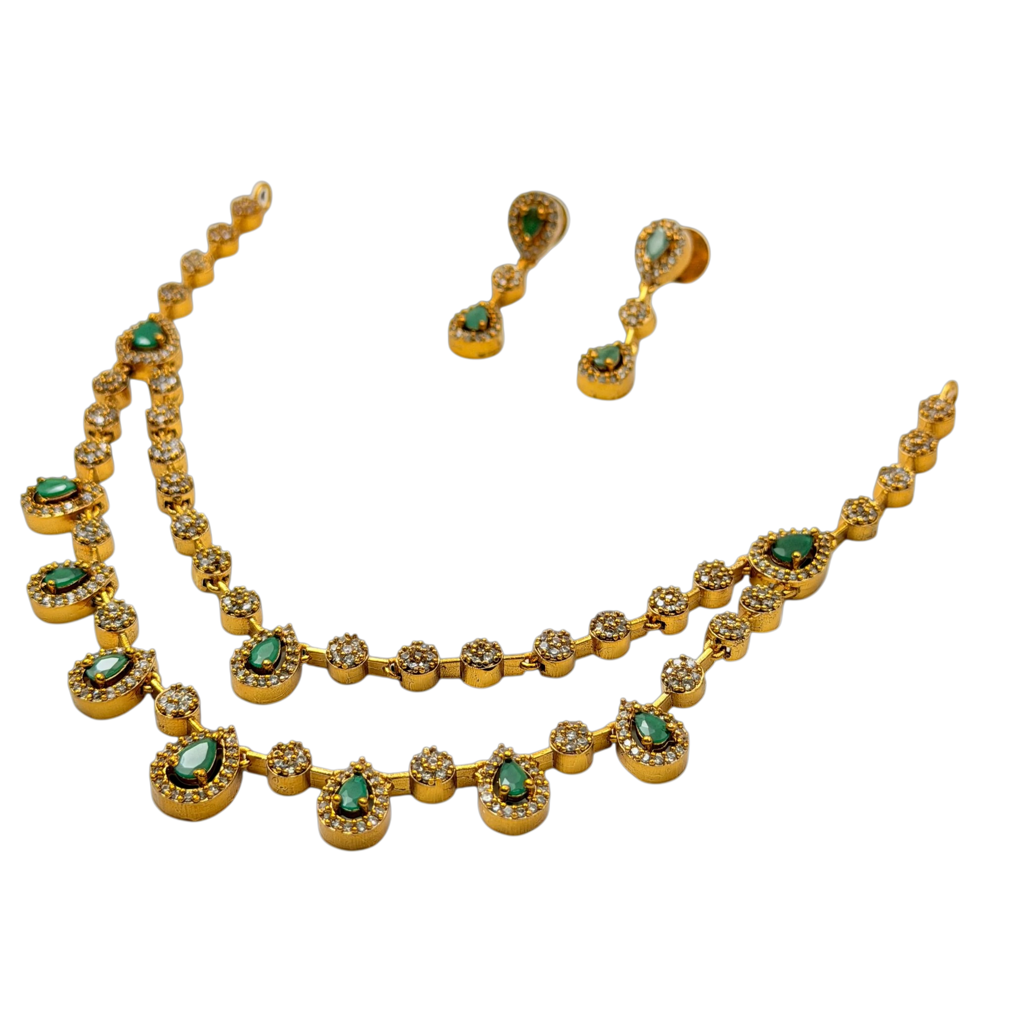 Gold necklace and earrings with green gemstones on a white background