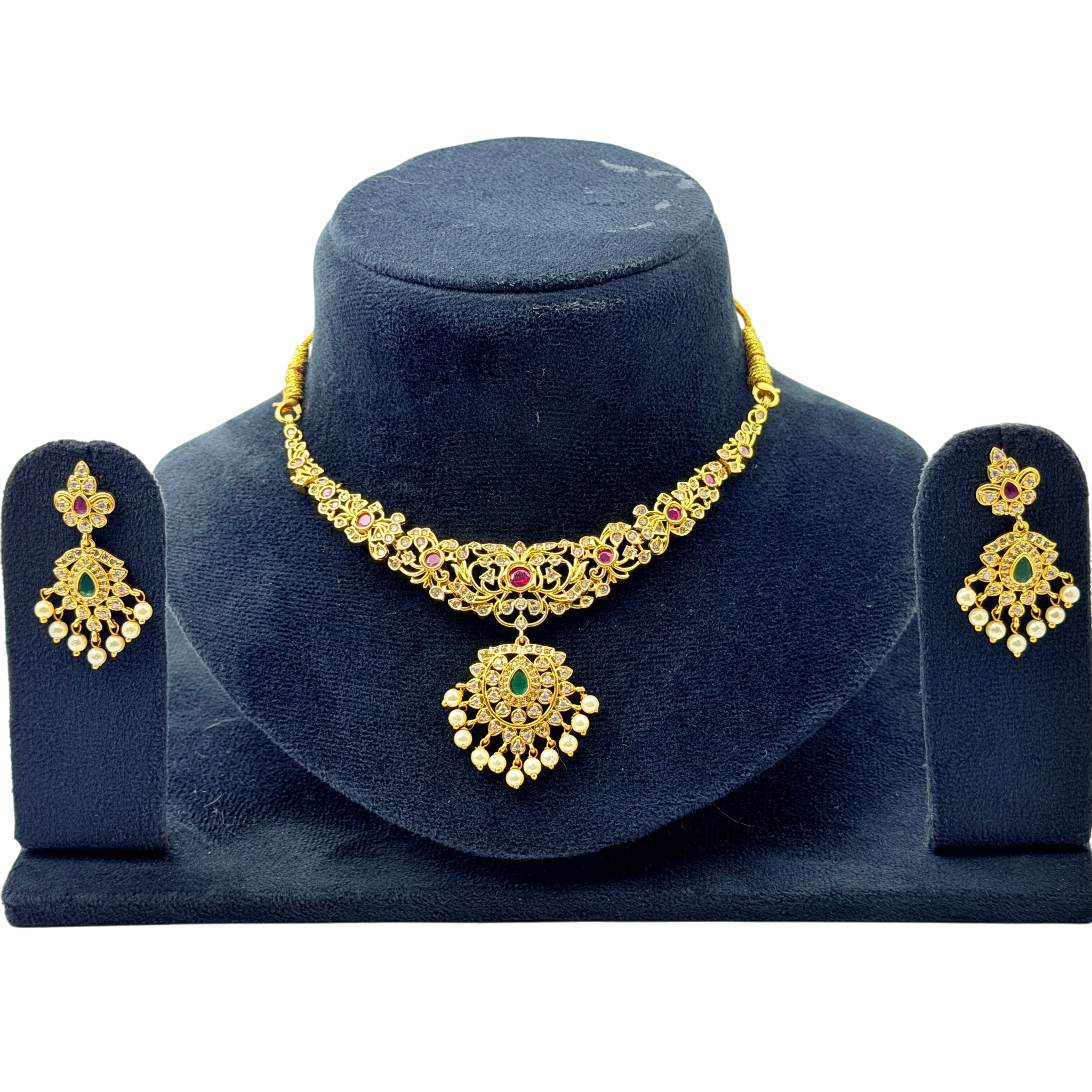Gold necklace and earrings set on a blue velvet stand
