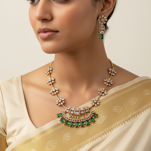 Woman wearing a gold necklace with emerald stones and matching earrings.