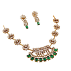 Gold necklace with green gemstones and matching earrings on a white background