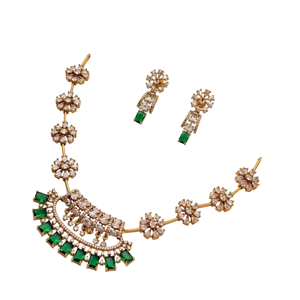 Gold necklace with emeralds and diamonds on a white background