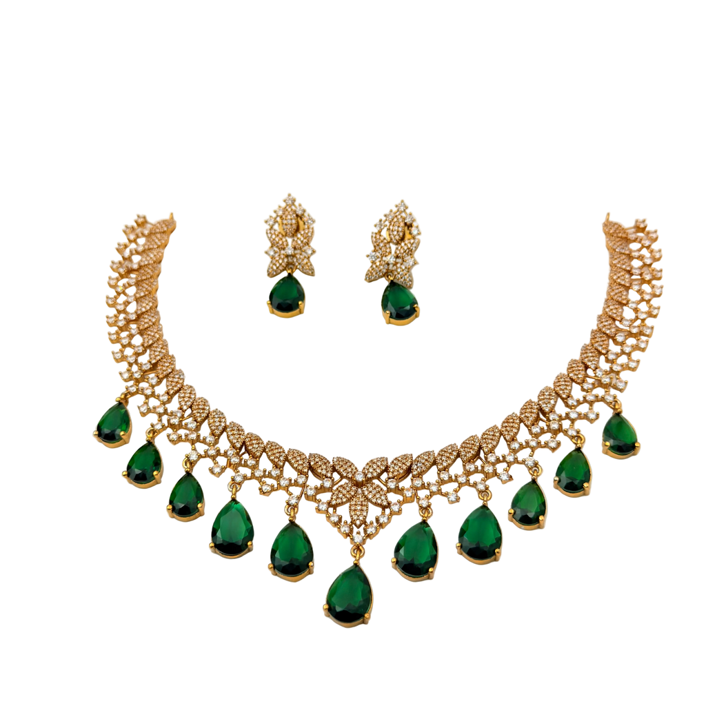 Gold necklace with green gemstones and matching earrings on a white background