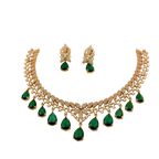 Gold necklace with green gemstones and matching earrings on a white background