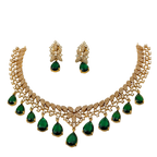 Gold necklace with green gemstones and matching earrings on a white background