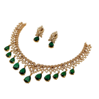 Gold necklace with green gemstones and matching earrings on a white background