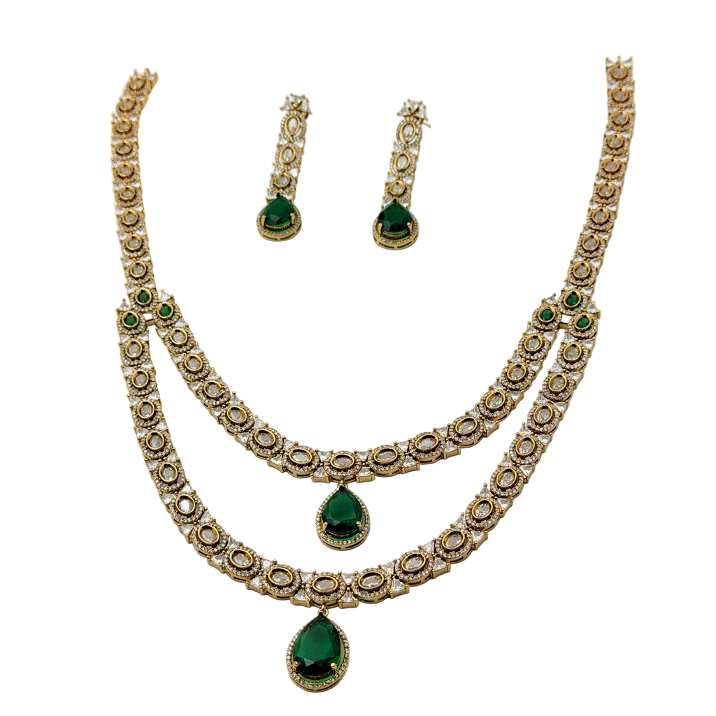 Jewelry set with necklace and earrings featuring green gemstones on a white background