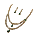 Jewelry set with necklace and earrings featuring green stones on a white background