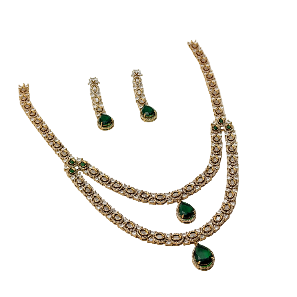Jewelry set with necklace, earrings, and rings featuring green gemstones on a white background
