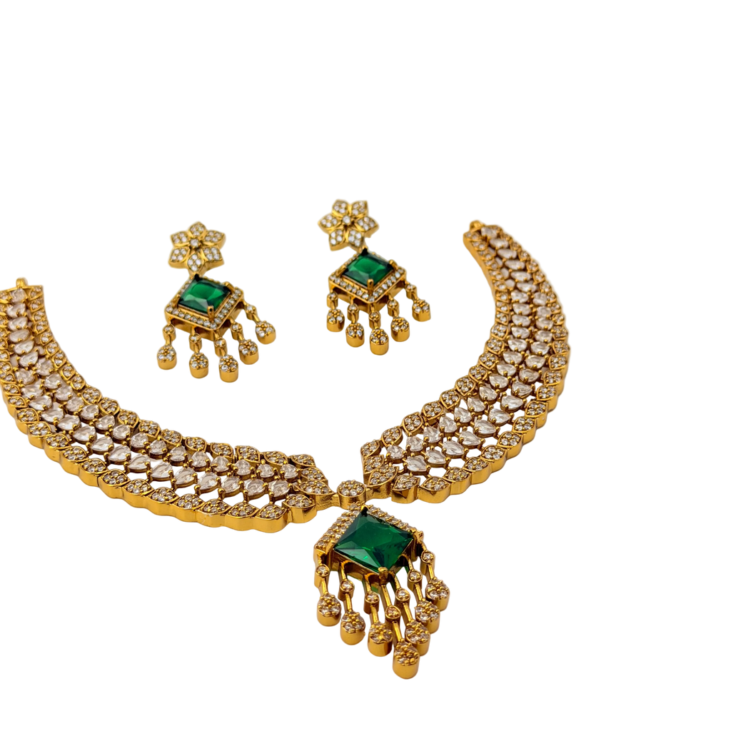 Gold necklace with green gemstones on a white background