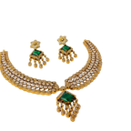 Gold necklace with green gemstones on a white background