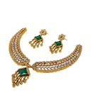 Gold necklace with green gemstones and matching earrings on a white background