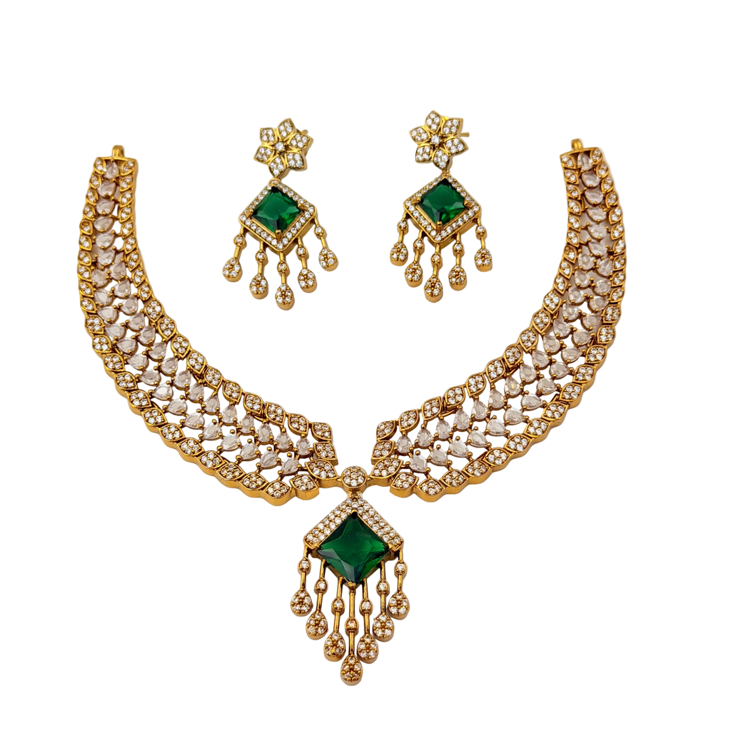 Gold necklace with green gemstones and matching earrings on a white background