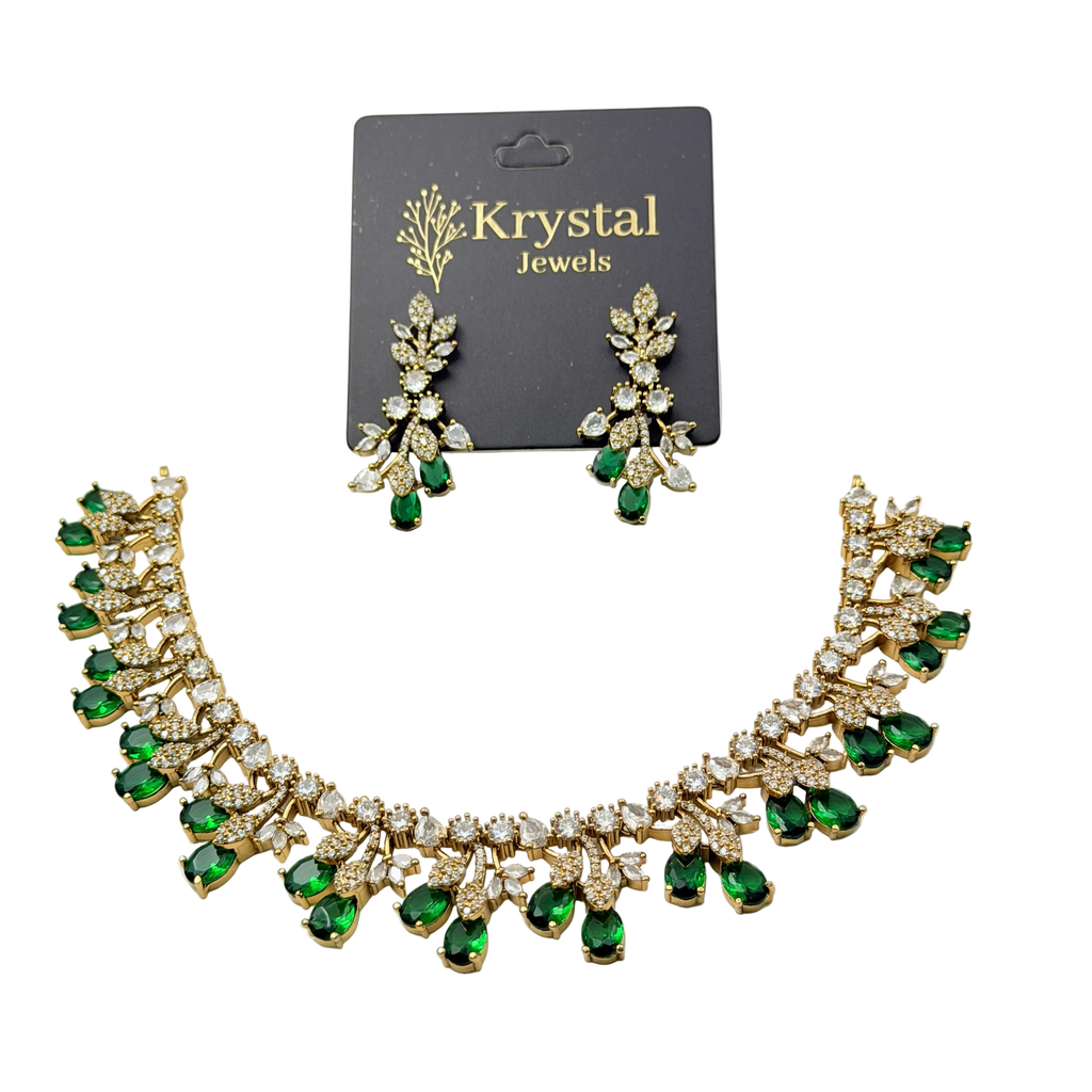 Necklace and earrings set with green gemstones on a Krystal Jewels card.