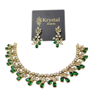 Necklace and earrings set with green gemstones on a Krystal Jewels card.