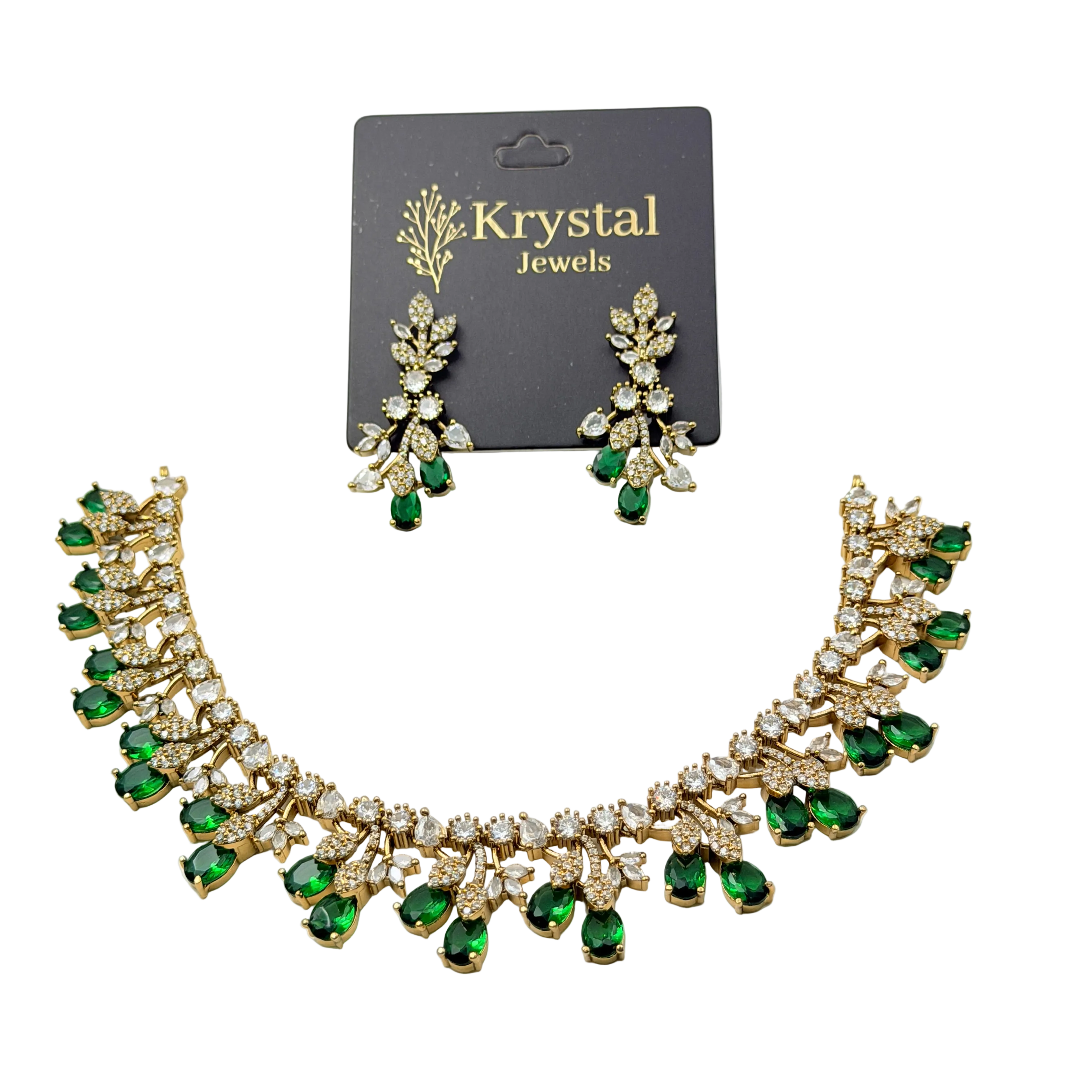 Necklace and earrings set with green gemstones on a Krystal Jewels card.