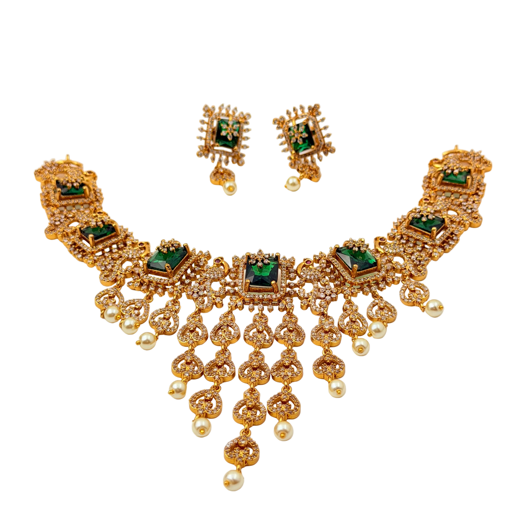 Gold necklace with green gemstones and matching earrings on a white background