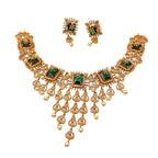 Gold necklace with green gemstones and matching earrings on a white background