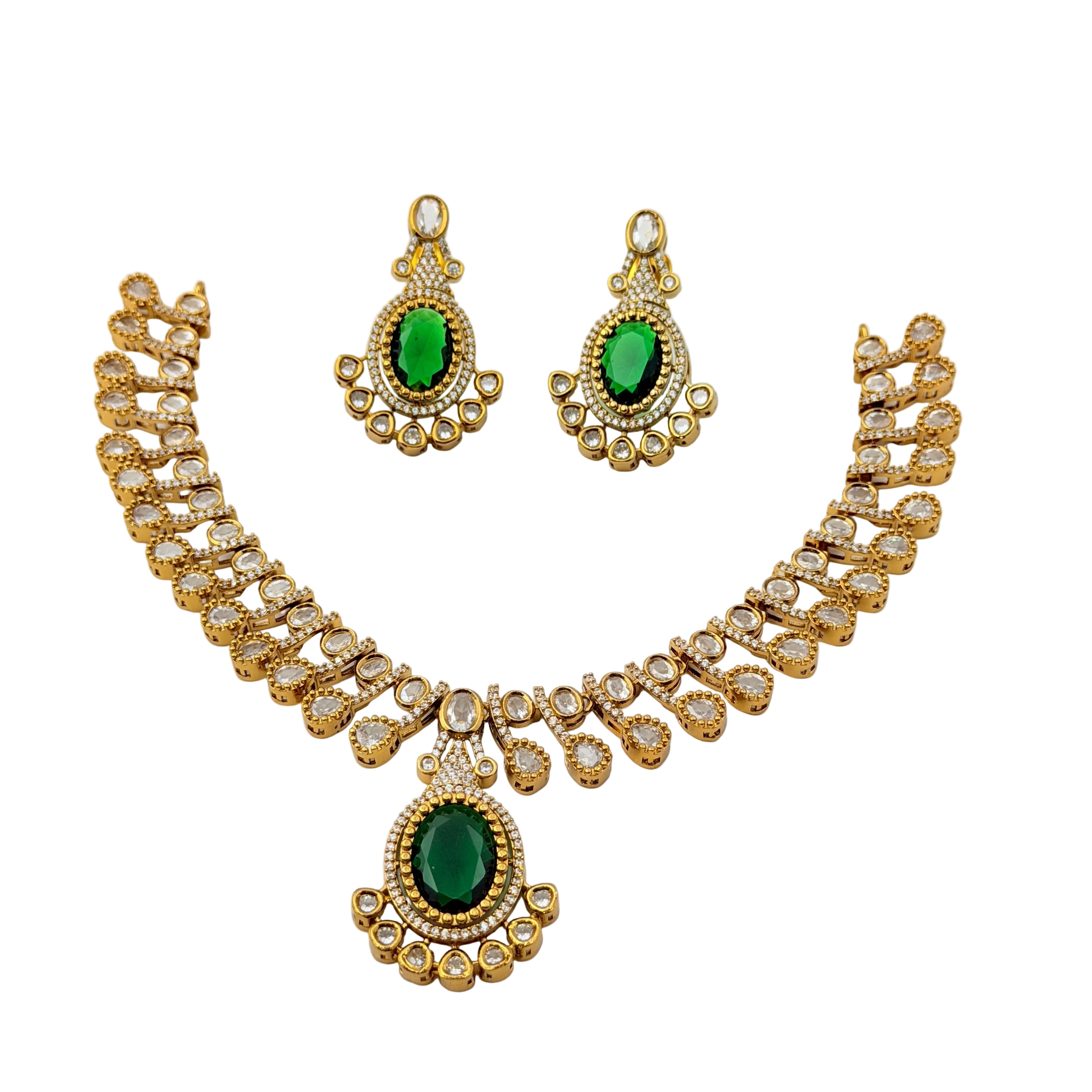 Gold necklace and earrings set with green gemstones on a white background
