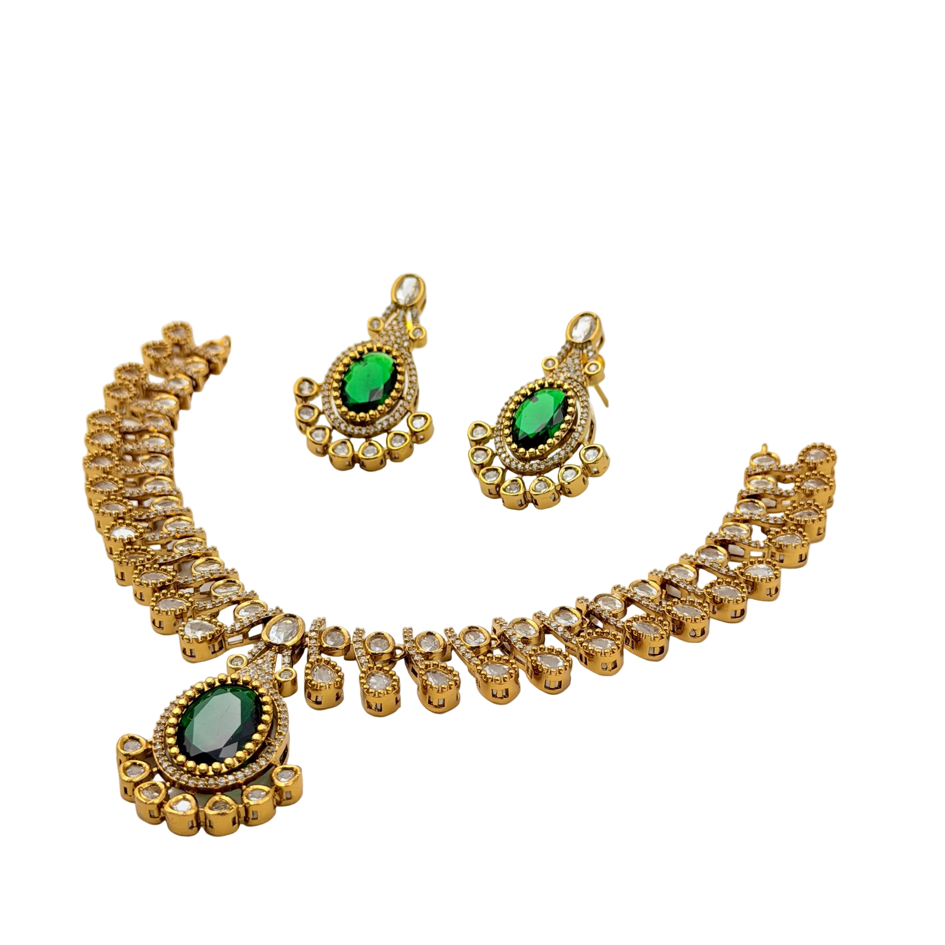 Gold necklace and earrings set with green gemstones on a white background