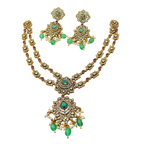 Gold necklace with green and red stones on a white background