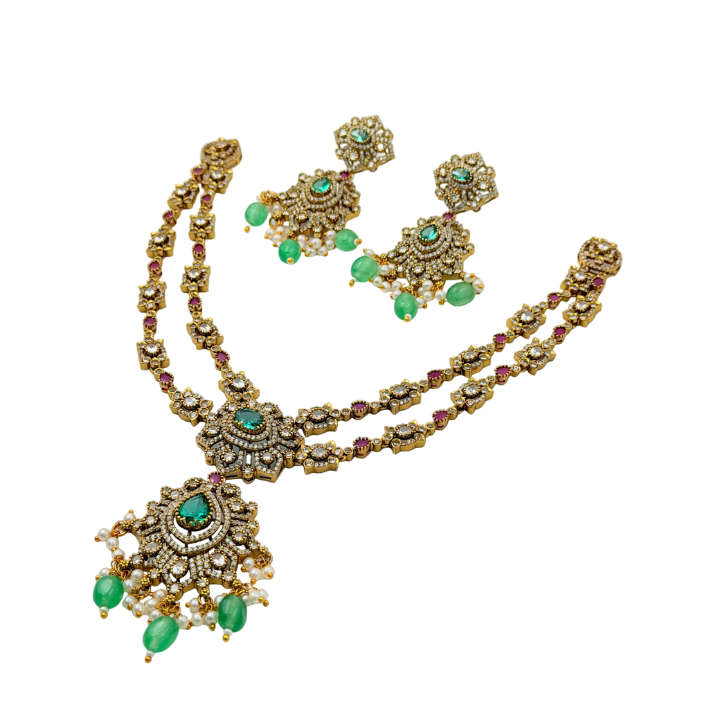 Gold necklace with green gemstones on a white background